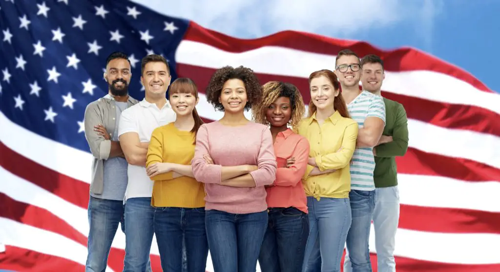 Diverse people in front of the American Flag representing the American Dream